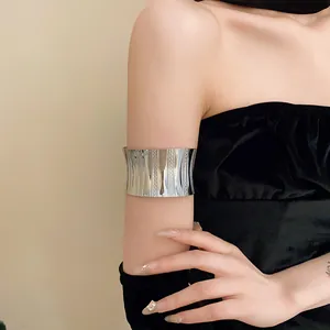 Fashionable high-shine silver textured wide arm cuff bracelet on the upper arm detail