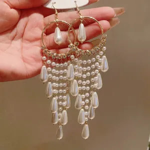 Close-up of vintage palace style long tassel earrings with white pearls and zircon accents