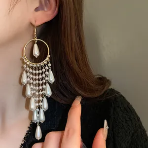 Detailed view of elegant long pearl tassel earrings with gold-tone circular frame