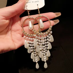 Close-up of vintage gold tassel earrings with cascading white pearls and zircons