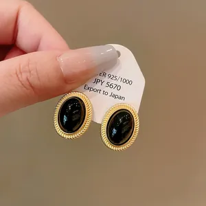 Vintage style oval earrings with black cabochon and gold twisted rope border detail.