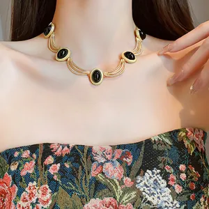 Close-up of a vintage palace-style gold choker with oval black cabochon stones