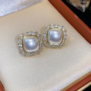 Close-up of elegant square pearl stud earrings with sparkling zircon halo