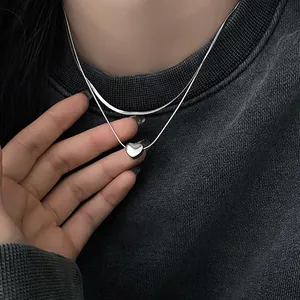 Exquisite close-up detail showing the silver double-layered heart pendant snake chain necklace
