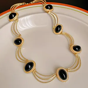 Detail shot of vintage palace style necklace with oval black stones and gold metal