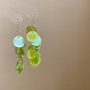 Macro detail view of layered translucent green round resin discs on gold earrings