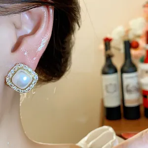 Elegant square pearl earring featuring sparkling zircon halo shown in a detailed close-up shot