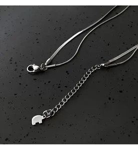 Close-up of a silver double-layered snake chain necklace with elephant charm detail