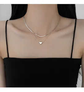 Close-up of minimalist double-layered silver snake chain necklace with heart pendant