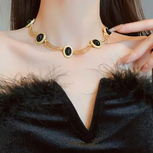 Close-up of vintage medieval style necklace with black oval stones and gold frame