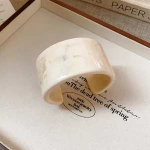 Close-up of a retro marble pattern wide cuff bracelet featuring an elegant cream finish
