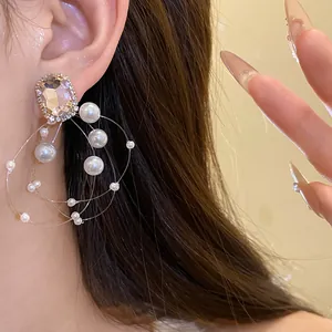 Dettaglio degli orecchini in argento con perle fluttuanti e gemma sfaccettata