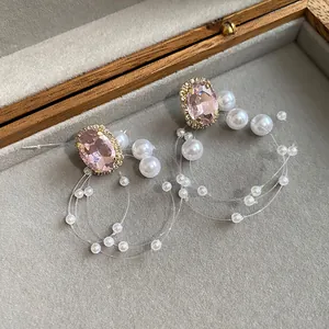 Primo piano di eleganti orecchini pendenti con cristallo rosa e perle stile vintage