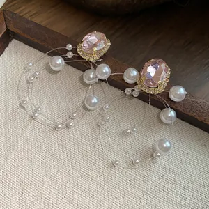 Dettaglio orecchini vintage francesi con cristallo rosa e pendenti di perle bianche