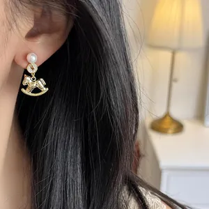 Elegant gold-plated rocking horse pearl earrings with sparkling crystals for women