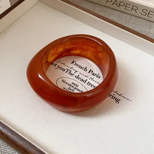 Detail view of a chunky retro amber resin bangle with unique wood grain patterns