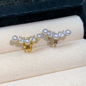 Close-up of elegant zircon and pearl ear cuffs in gold and silver finish, non-pierced