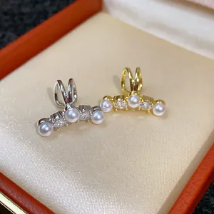 Close-up detail of elegant non-pierced zircon pearl ear cuffs in gold and silver