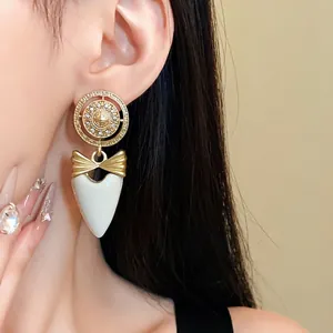 Vintage bow and heart drop earrings featuring a crystal-embellished Greek key circle design