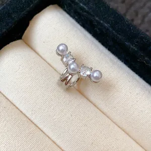Exquisite close-up detail of a silver ear cuff featuring lustrous pearls and shiny zircons