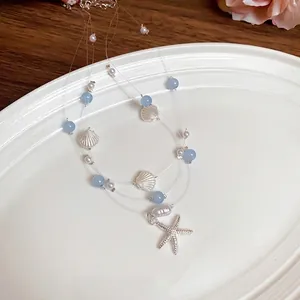 Multi-layered beach necklace with blue beads, pearls, shells, and a starfish pendant