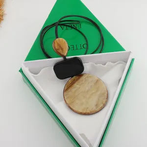 Detailed view of geometric resin necklace with marble pattern and black cord