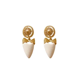Vintage-style gold bow heart earrings with rhinestones and Greek key pattern design