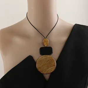 Macro view of oversized resin geometric necklace with marble pattern on a mannequin