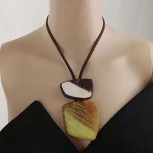 Geometric resin pendant necklace with brown leather cord and marble texture detail