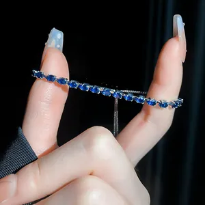 Detailaufnahme eines eleganten Silberarmbands mit blauen birnenförmigen Steinen.