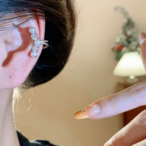 Detailed close-up view of an elegant silver zircon and pearl ear cuff worn on the ear