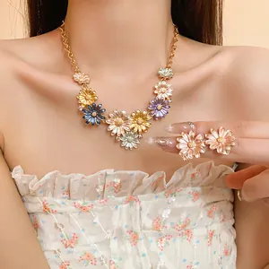 Elegant floral enamel necklace and matching earring set with rhinestones worn by a model