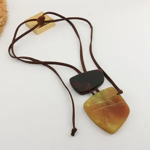 Close-up of resin marble geometric pendant with brown faux suede cord necklace