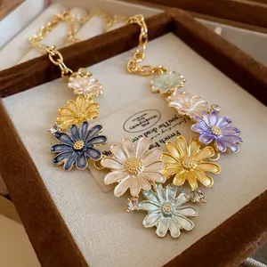 Detail view of a colorful enamel daisy necklace with rhinestones in a brown jewelry box