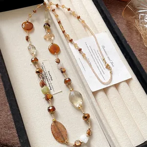 Detailed view of a Bohemian beaded necklace with multi-colored stones in a display box.