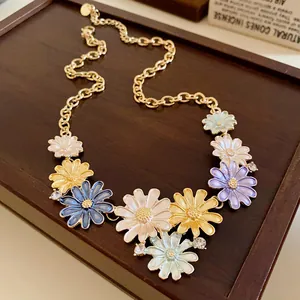 Charming floral enamel necklace with sparkling rhinestones on a wooden jewelry tray