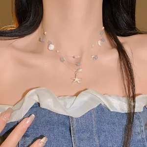 Close-up of layered necklace featuring starfish, pearls, and shells for vacation style