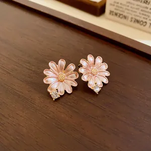 Elegant macro detail of pink enamel daisy flower earrings with sparkling rhinestone