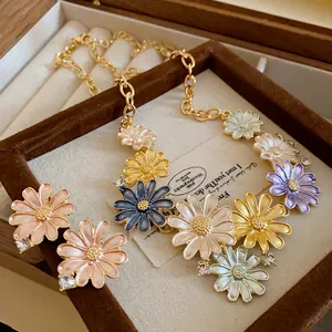Close-up of colorful enamel daisy necklace and earrings in a wooden jewelry box.