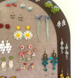 A variety of Mori style floral and butterfly tassel earrings displayed on a felt board