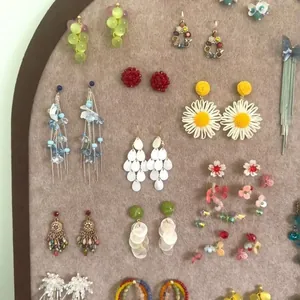 Collection of forest-style floral and butterfly tassel earrings displayed on a board