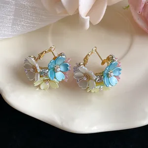 Close-up of elegant French-style floral hoop earrings with colorful petals and rhinestones