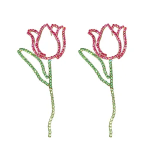 Sparkly tulip-shaped rhinestone earrings with pink and green stones on white background