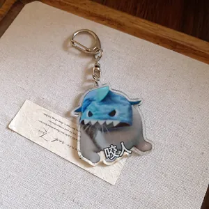 Detail view of a cute acrylic cat keychain wearing a shark hat with funny meme design