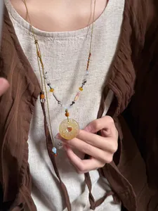 Detailopname van Chinese stijl ketting met gesneden hars hanger en agaat kralen