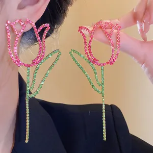 Macro detail of tulip flower earrings with pink and green rhinestones on silver needles