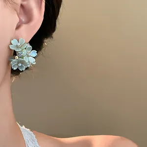 Detailed close-up of sweet French-style flower stud earrings with small rhinestones