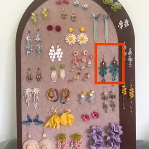 Detailed view of bohemian forest style blue beaded tassel dangle earrings on a display board