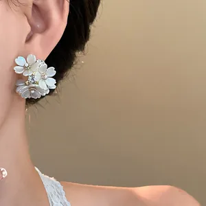 Detailed side view of elegant floral cluster stud earrings with rhinestones on ear