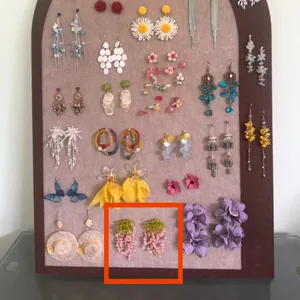 Large display board showcasing a variety of floral and butterfly dangle earrings